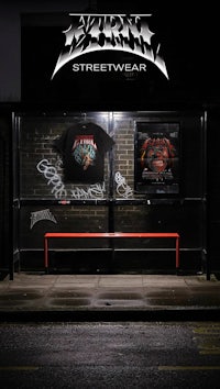 a bus stop with a bench and a t - shirt in front of it
